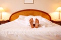 Woman relaxing on bed with white sheets