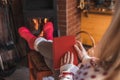 Woman relaxing with book in front of fireplace at home interior