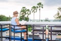 Woman relaxing with a book at the sea. Young woman reading at outdoor beach cafe