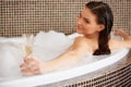 Woman Relaxing In Bubble Bath With Rose Petals. Body Care