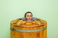 Woman in cedar spa barrel body rejuvenation and relax sauna