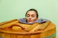 Woman in cedar spa barrel body rejuvenation and relax sauna