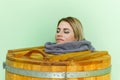 Woman in cedar spa barrel body rejuvenation and relax sauna