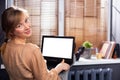 Woman relaxing on a chair, putting her foot on the window at home, working in front of opened laptop with white mock up Royalty Free Stock Photo