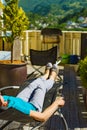 Woman relaxing in chair on veranda