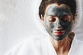 Woman relaxing with a charcoal facial mask