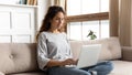 Woman relaxing on couch using laptop search information on internet