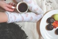 Woman relaxing in cozy place with sweets and a cup of tea. Royalty Free Stock Photo