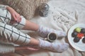 Woman relaxing in cozy place with sweets and a cup of tea. Royalty Free Stock Photo