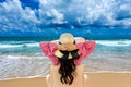 Woman relaxing on deck chair at beach and looking at ocean Royalty Free Stock Photo