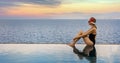 woman relaxing on the edge of infinity swimming pool at luxury resort. summer vacation. copy space Royalty Free Stock Photo