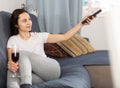 Woman relaxing at evening with glass of red wine on sofa Royalty Free Stock Photo