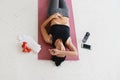 Woman relaxing on fitness mat after workout at home.