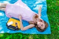 Pretty young woman relaxing on the grass in a park listening to music on her mobile phone Royalty Free Stock Photo