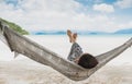 Woman relaxing in the hammock with her feet up in tropical beach on summer vacation. Royalty Free Stock Photo