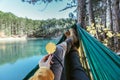 Woman relaxing in the hammock by the lake Royalty Free Stock Photo