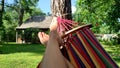Woman relaxing on a hammock by the outdoor village, mid shot