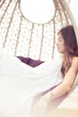 Woman relaxing on hammock with white dress sunbathing on vacation