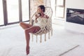 Woman relaxing at home in hanging chair