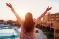 Woman relaxing at hotel balcony enjoying sunrise with swimming pool and sea view Royalty Free Stock Photo