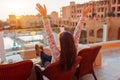 Woman relaxing at hotel balcony enjoying sunrise with swimming pool and sea view Royalty Free Stock Photo