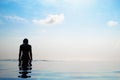 Woman relaxing in infinity swimming pool looking at view Royalty Free Stock Photo