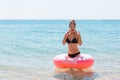 Woman relaxing with inflatable ring on the beach. shocked or surprise girl in the cold sea. Summer holidays and vacation concept Royalty Free Stock Photo