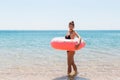 Woman relaxing with inflatable ring on the beach. shocked or surprised girl in the cold sea. Summer holidays and vacation concept Royalty Free Stock Photo