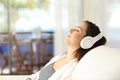 Woman relaxing listening to music on a couch Royalty Free Stock Photo