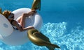 woman relaxing in luxury swimming pool resort hotel on big inflatable unicorn floating pegasus float Royalty Free Stock Photo