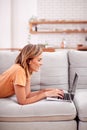 Woman Relaxing Lying On Sofa At Home Using Laptop Computer Royalty Free Stock Photo