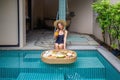 A woman relaxing in a modern tropical villa swimming pool Royalty Free Stock Photo