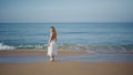 Woman relaxing ocean shore walking on foamy waves alone. Relaxed model strolling Royalty Free Stock Photo