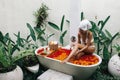 Woman relaxing in outdoor bath with flowers in Bali spa hotel Royalty Free Stock Photo