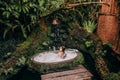 Woman relaxing in outdoor bath with tropical jungle  luxury spa hotel, lifestyle Royalty Free Stock Photo