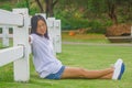 Woman is relaxing at outdoor garden. She sitting on green grass. Royalty Free Stock Photo