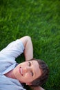 Woman relaxing in park. Portrait of relaxed mature woman smiling while lying on grass. Royalty Free Stock Photo