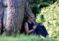 Woman relaxing in a park reading, mature blonde. for many, reading is a way to rest from stress, but it is also very healthy becau