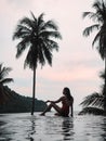 Woman Relaxing By The Pool In A Luxurious Beachfront Hotel Resort At Sunset Enjoying Perfect Beach Holiday Vacation. Tropical Beac