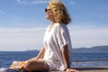 Woman relaxing and reading on a sailboat