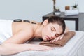 Woman relaxing and receiving hot stone massage in spa salon Royalty Free Stock Photo