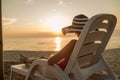 Woman relaxing on a recliner at the beach