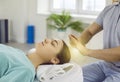 Woman relaxing and restoring energy during holistic healing session with Reiki therapist Royalty Free Stock Photo