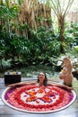 Woman relaxing in round outdoor bath with tropical flowers, organic skin care, luxury spa hotel, lifestyle photo Royalty Free Stock Photo