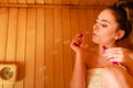 Woman relaxing in sauna room blowing soap bubbles Royalty Free Stock Photo