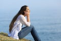 Woman relaxing sitting on the grass watching the sea