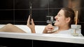 Woman relaxing in a soothing bath while having a video call on her tablet computer. Best to promote the idea of digital detoxing