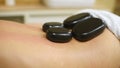 Woman relaxing in spa salon with hot stones.