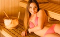 Woman relaxing in spa sauna with bucket. Wellbeing Royalty Free Stock Photo