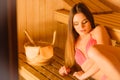 Woman relaxing in spa sauna with bucket. Wellbeing Royalty Free Stock Photo